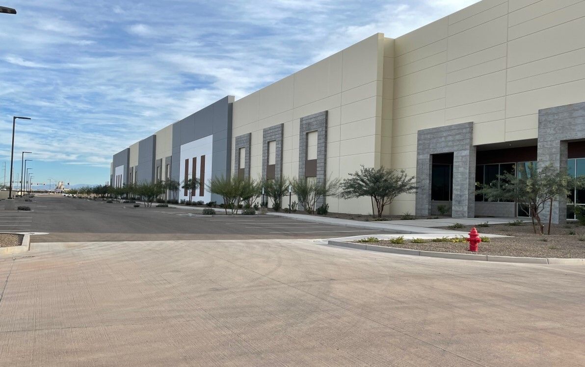 a large distribution center and parking lot with a blue sky